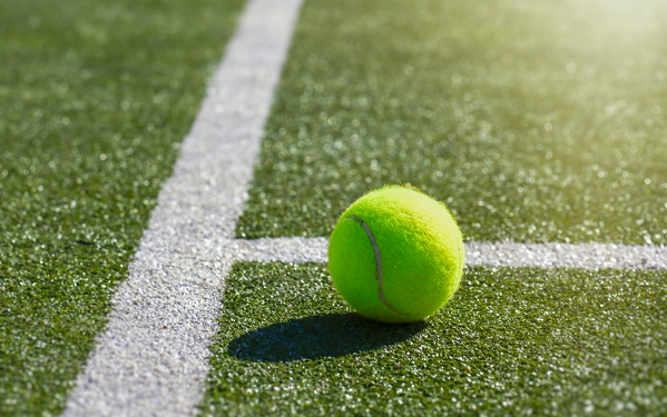 Tennis ball near line on court
