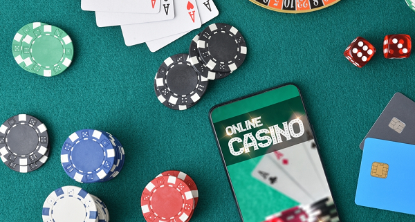 online casino on phone on table next to casino chips and cards