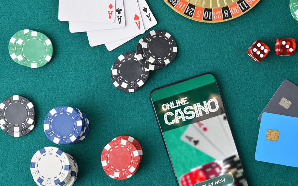 online casino on phone on table next to casino chips and cards